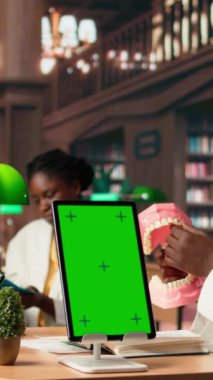 Dikey Video Tıp öğrencisi, dişçilik uygulamalarını yapay çene modelinin yanında öğreniyor ve tekniklerle diş kalitesini geliştiriyor. Sınav hazırlıkları için çalışma araçları. Kamera A.