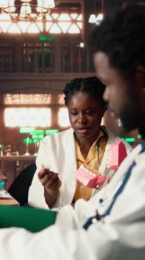 Dikey Video Afrikalı Amerikalı diş hekimliği öğrencileri yaklaşan sınavlar için dişleri inceliyor, kütüphanede çene modeli kullanarak doğum kontrol seansı öğreniyor. Oral sağlık eğitimine adanmışlık. Kamera.