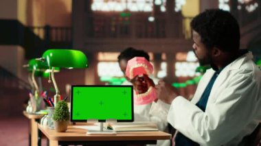 Tıp öğrencisi dişçilik uygulamalarını mankenin yanındaki sahte çene modelinde öğreniyor, tekniklerle diş kalitesini geliştiriyor. Sınav hazırlıkları için çalışma araçları. Kamera B.