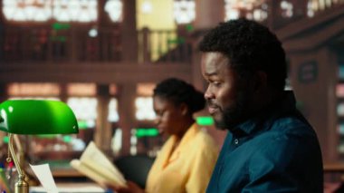 Stresli erkek öğrenci, yaklaşan sınav notlarını ezberlemenin akademik mücadelesi yüzünden hayal kırıklığına uğramış hissediyor. Öğrenci üzgün ve notları için endişeleniyor. Kamera B.