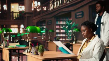 Afro-Amerikan tıp fakültesi kütüphanedeki özel kitaplardan ders alıyor, tıbbi araştırmalarını yapıyor ve sağlık yöntemlerini öğreniyor. Kariyeri için çok çalışan bir kadın. Kamera A.