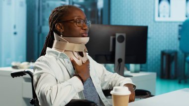 Afrikalı Amerikalı hasta, doktor kontrolünde rahim boynu kırığı olan bir hastayla ilgilenen tekerlekli sandalye kullanıcısı tasma takıyor. Uzman doktorla omurilik iyileşme yolu. Kamera A.