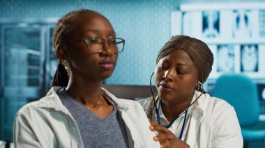 Pratisyen hekim, hastaya hastalık konusunda danışmak için steteskop kullanır. Akciğerlerin ve kalp atışlarının normal çalışmasını sağlar. Sağlık kontrolünde solunum sorunu olan Afrikalı Amerikalı bir kız. Kamera A.