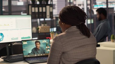 Siyahi direktör, yeni bir strateji için iş danışmanlarıyla bir video görüşmesi yapıyor, hedefler belirlemek için çevrimiçi konferansta uzaktan iletişimi kullanıyor. Uzmanla bağlantı. Kamera A.