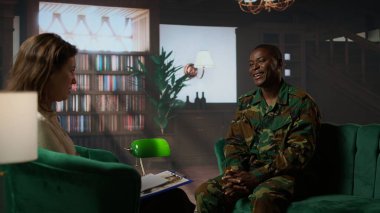 Black military officer in army uniform attends counseling session, looking distressed and opening up about post traumatic combat stress. War soldier dealing with shell shock. Camera A. clipart