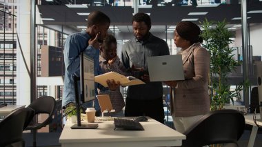 Çok uluslu şirket çalışanları, kaynak tahsisi ve performans ölçüm verilerini tartışarak büyümeye odaklı bir proje planlamak üzere bir araya geldiler. Siyahi iş adamları hedeflerine etkili bir şekilde ulaşırlar. Kamera B.