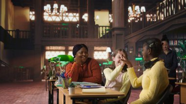 Özel seanslar sırasında çeşitli kızlara eğitim veren Afrikalı Amerikalı öğretmen, kütüphanede ödev ve okul projelerinde yardımcı oluyor. Başarı için özel ders veriyorum. Kamera A.