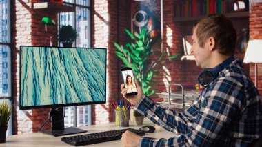 Merkez ofisteki adam çevrimiçi içerik yaratıcılarının canlı yayınlarıyla sosyal medyaya bakıyor. Etkilenenler tarafından yapılan canlı yayınlarla sosyal ağ uygulaması kullanan çalışanlar, kamera A