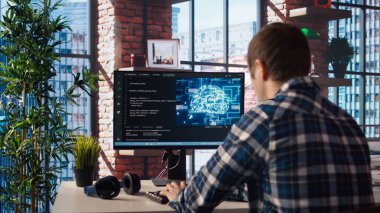 Geliştirici bilgisayarda kod yazıyor ve yapay zeka sinir ağları üzerinde bakım yapıyor bilgisayarlı model. Klavyede yazım uzmanı var. Yapay zeka sistemlerini kontrol ediyor. Kamera A.