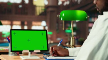 Gelecekteki sağlık hizmetleri uzmanı kampüs kütüphanesindeki uzay ekranının yanında tıbbi yöntemler üzerinde çalışıyor, dava dosyalarını ve araştırma belgelerini okuyor. Siyahi adam akademik gelişim üzerine çalışıyor. Kamera B.