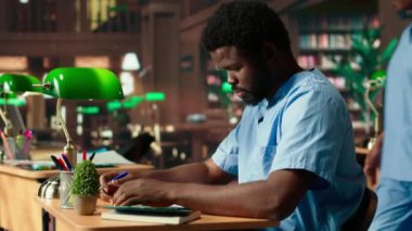 Tıp asistanı kütüphanede yeşil bir lambanın altında kitap okuyor, tıbbi yöntemler hakkında araştırma yapıyor ve sınavlara hazırlanıyor. Genç adam kariyerine bağlılığını gösteriyor. Kamera B.