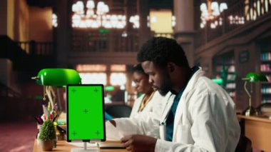 Afrika kökenli Amerikalı bir öğrenci kütüphanenin yanındaki ameliyat notlarını okuyarak yaklaşan sınav için çok çalışıyor. Genç adam, başarılı bir sağlık kariyeri kurmaya odaklandığını vurguluyor. Kamera A.