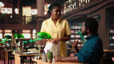 Afrika kökenli Amerikalı öğrenciler derslerini sessiz bir kampüs kütüphanesinde okuyorlar, akademik kaynak ve materyalleri eğitim gelişimine yardımcı olmak için kullanıyorlar. Çalışma zamanı. Kamera A.