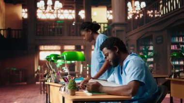 Eğitimdeki Afrikalı Amerikalı hemşireler tıp fakültesi ödevleri ve notları gözden geçiriyorlar, birlikte öğreniyorlar ve kampüs kütüphanesinde sınavlara hazırlanıyorlar. Tıp kariyeri için sağlık muayenehanesi. Kamera A.