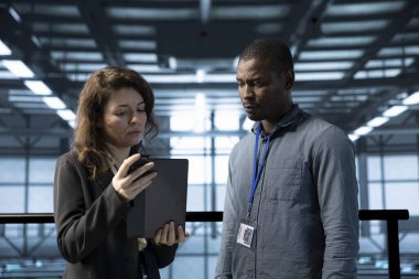 Veri merkezindeki programcılar tabletteki otomasyon araçlarını kullanıyorlar. Bilgi İşlem uzmanı ve meslektaşı sunucu çiftliğinin sürekli güncellenmesini sağlarken, veri akışını aygıtla yönetir