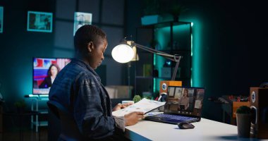 Çalışan evde çalışıyor. Müdürle iş görüşmesi yapıyor. Mali tabloları görmek istiyor. Uzaktan telekonferanslı telgraf işçisi. Ekip lideri görev ilerlemesini gösteriyor. Kamera B.