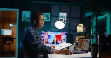 Serbest meslek sahibi bir kadın dizüstü bilgisayardaki istatistiksel veri grafiklerini kontrol ediyor, içgörüleri araştırıyor. Uzaktan çalışan, iş dünyasının grafiksel rakamlarını karşılaştıran, strateji yapan, kamera B