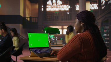 Sessiz bir halk kütüphanesinde krom anahtarla dizüstü bilgisayarda yazan siyahi kütüphaneci, çalışma kaynaklarını organize etmeye ve öğrencilere akademik yolculuklarında gururla akıl hocalığı yapmaya adanmış. Kamera A.