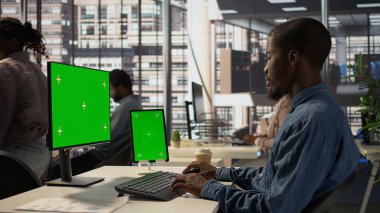 Siyahi işadamı, krom anahtar ekranın yanında finansal verileri analiz ediyor, bilgisayar üzerinde şirket stratejilerini gözden geçiriyor ve iş geliştirme ve karar verme sürecine katkıda bulunuyor. Başarılı bir hava tahmini. Kamera B.