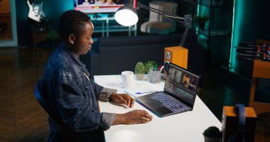 Yaratıcı ofiste renk derecelendirme ve ışıklandırma düzenlemesinden önce dizüstü bilgisayardaki film montajını analiz eden video editörü. Not defterinde ham görüntülerle çalışan prodüksiyon stüdyosu çalışanı, B kamerası