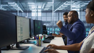 Şaşırmış veri merkezi teknisyeni, siber güvenlik çerçevesini kurmayı, güvenlik olaylarını azaltmayı ve veri koruma protokollerini ve kamera A 'yı başarıyla başardıktan sonra kutlama yapıyor.