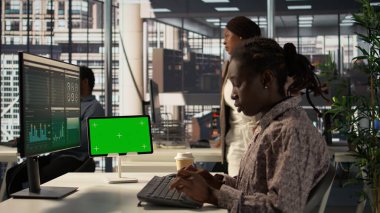 Şirket raporlarını inceleyen Afrikalı Amerikalı bir işçi stratejik planlar üzerinde çalışmak için kopya uzay gösterimine bakıyor. İş operasyonları ve büyüme konusunda uzmanlık gösteren bir kız. Kamera B.