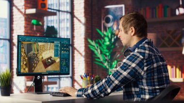 Ev ofisinin mimari tasarımcısı, 3 boyutlu modelleme programındaki varlıkları taşıyor, iç tasarım projesi yapıyor. Bilgisayardaki CAD yazılım arayüzüne bakan adam, ev kat planları yapıyor, kamera B