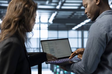 Veri merkezi yazılım geliştiricileri tarafından kullanılan defter ekipman teşhislerini gözden geçiriyor. Dizüstü bilgisayarda kodlama yapan programcılar, sunucu çiftlik yapılandırmalarını ayarlayan, hata durumlarını temizleyen, yazılım güncellemelerini uygulayan programcılar