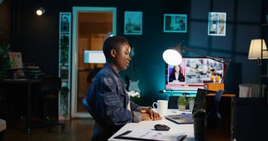 Ofisteki iş görüşmesi sırasında iş arkadaşlarıyla iş yerinde konuşan bir çalışan. Uzaktan telekonferansla konuşan tele-işçi, oturma odasından, kamera B