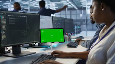 Bilgi işlem uzmanları, veri işleme gereksinimleri için sunucu çiftliğinde birlikte çalışarak yeşil ekran tableti kullanıyorlar. Veri merkezinde krom anahtar aygıtı kodlayan iş arkadaşlarını kapat, kamera A