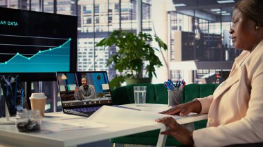 Siyahi yönetmen telekonferans çağrısında hissedarlara yeni bir proje sunarak küresel kalkınma için finansman konusunu tartışıyor. İş büyümesi tutkusu olan kadın CEO. Kamera B.