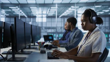 Sunucu çiftliğinde çalışırken zamanı daha hızlı geçirmek ve veri işleme gereksinimleri için optimize etmek için gülümseyen mühendis işitme podcast 'lerinin portresi. Mutlu kadın veri merkezinde, kamera A 'da şarkılar dinliyor.