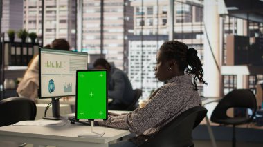Çalışan kadın yönetici, yeşil ekranlı cihazlarla iş yerinde oturmuş, işletme büyümesi için idari görevler üzerinde çalışıyor. Sağlam hedefleri desteklemek için performans ölçümleri geliştiriyorum. Kamera B.