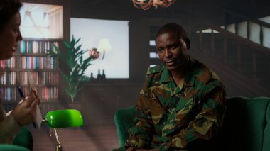 Afrika kökenli Amerikan askeri üniformalı asker bir uzmanla oturup Rorschach 'ın test örneklerini izleyip travmayı tartışır. Travma Sonrası Stres ve savaş bunalımı danışmanı. Kamera A.