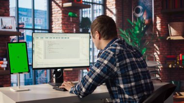 Bilgisayar kodlamada yazılım mühendisi, izole ekran tableti kullanarak yazılım yaratıyor. Bilgi İşlem uzmanı. Kod düzenleyicisi ile çalışıyor. Bilgisayar ve model cihazı kullanarak uygulamalar geliştiriyor.