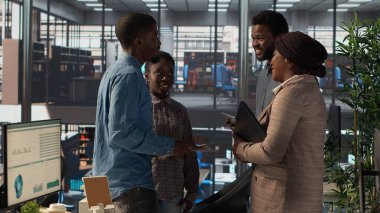 Afrika kökenli Amerikan idari personeli, analitik raporları ve şirket verilerini etkin yönetim hedefleriyle aynı hizaya getirmek için gözden geçirir. Kamera A.