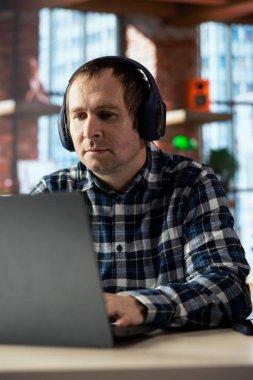 Müzik dinleyen işçiler, masadaki bilgisayardaki verileri analiz eden, analitik raporları derleyen. İşçi kulaklık takıyor, defter aygıtı kullanıyor, bilgi yazıyor, projeyi bitiriyor