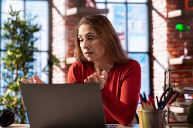 İnternet üzerinden sanal atölye kursuna katılan kişi, merkez ofisteki webcam 'e el sallıyor. İnteraktif öğrenme oturumu için video konferansına katılan kadın.