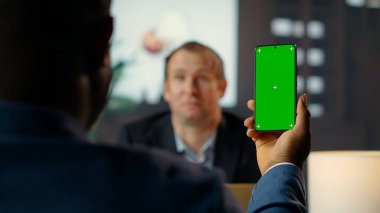 Çeşitli personel CIA 'in güvenli evindeki ahşap bir kütüphanede yeşil ekran teknolojisi ve istihbarat analizini harmanlayarak belgeleri inceliyor. Kritik görev detayları hakkında birbirimize brifing veriyorduk. Kamera B.