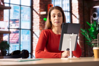 Female remote worker smiling during a virtual meeting with her trainer, showcasing the effectiveness of online tools and internet connection. Woman starting her training session for the new job. clipart