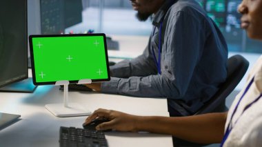 Sistem yöneticileri tarafından en az arayı sağlamak için kullanılan sunucu odasındaki yeşil tableti kapat. Veri merkezi yazılım geliştiricileri krom anahtar cihazına bakıyor, performansı izliyor, kamera A