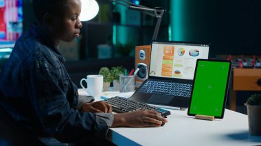 İzole ekran tableti kullanan serbest çalışan oturma odasındaki dizüstü bilgisayardaki istatistiksel çizelgeleri analiz ediyor. Uzaktan çalışan krom anahtar elektronik aygıtın iş gelirlerini kontrol ediyor