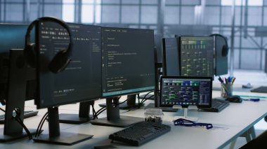 Boş veri merkezindeki elektronik cihazlar donanım enerji tüketimini izliyor. Sunucu odasındaki potansiyel sistem arızalarını ve el kamerası görüntülerini kontrol etmek için kullanılan masadaki bilgisayar monitörleri