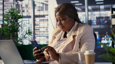 Kadın CEO sosyal medyada ekibiyle iş fikirlerini tartışıyor, proje güncellemelerini mesajla alıyor. Kara hedef odaklı kararlılıkla girişimci. Kamera B.