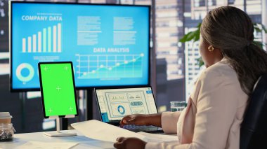 Tabletinde izole edilmiş kopya alanı olan kadın genel müdür dizüstü bilgisayarında veri analizleriyle finansal planlama üzerinde çalışıyor. Başarı için finansmanı arttıracak bir strateji geliştiriyorum. Kamera A.