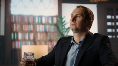 Seçkin sosyal kulüpte bir bardak viski içip servetini ikiye katlama fırsatını düşünen zengin varis. Alkol yudumlayan zarif üst sınıf milyarder beyefendi. Kamera A.