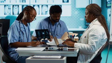 Afro-Amerikalı doktor hemşireleriyle tedavi seçenekleri bulmak, sağlık sektöründe takım çalışması ve profesyonelliği göstermek için tartışıyor. Klinikteki hizmetleri geliştiriyorum. Kamera A.