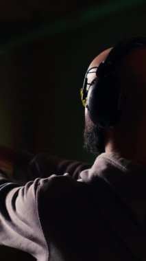 Dikey video çekim galerisi müşterisi hedefleri vurmak için tabanca kullanıyor ve kulaklık takıyor. Atış poligonunda kulaklık takan, boğa avlayan, silah kullanmaktan zevk alan biri.