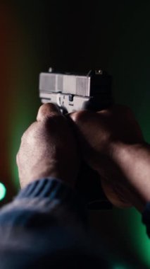 Dikey video atış poligonu müşterisi tabancayla ateş edip etmediğini kontrol ediyor. Atış poligonunda silah kullanmayı öğrenen, vurulan hedefleri analiz eden kişiye yaklaş.