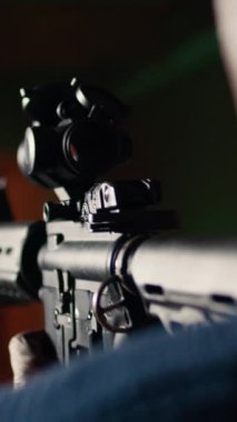 Dikey video çekimi galerisi müşterisi, kağıt hedefleri mermilerle vuruyor, tüfeklere çok yakın. Atış poligonunda yakın çekim yapan kişi boğa vuruyor, yarı otomatik olarak eğleniyor.